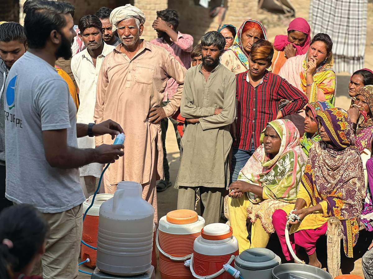 A crowd of families gathers to learn how to use their new water filters
