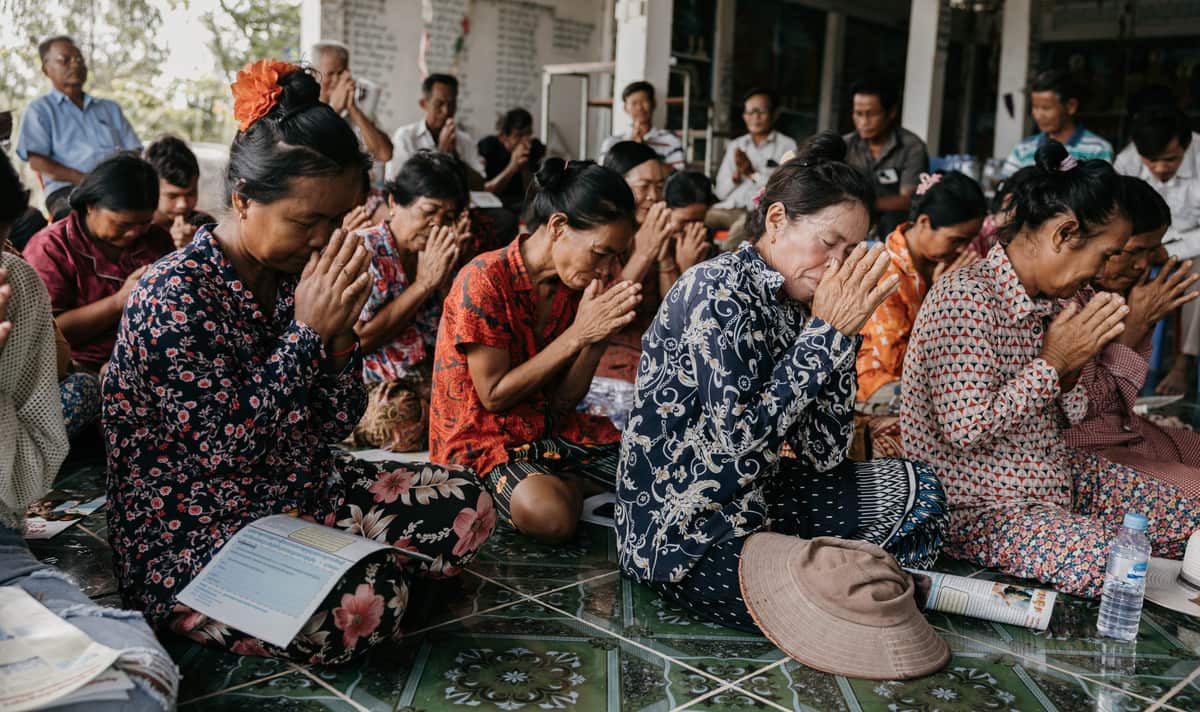 Believers kneel and pray together during a church gathering