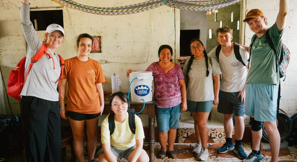A Filter of Hope mission team stands with a family and their new water filter