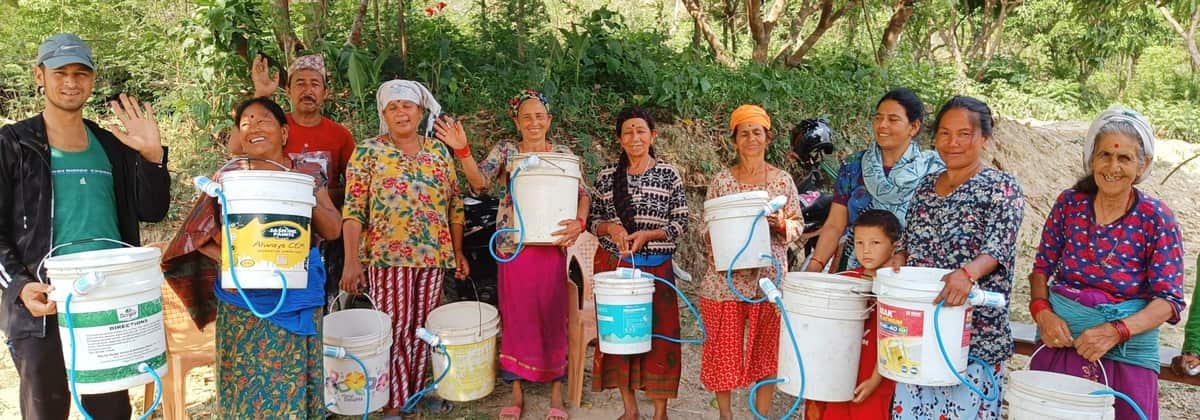 Women in Nepal hold up their new filter buckets