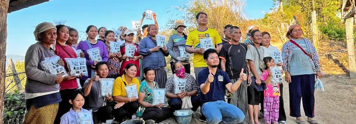 Families in Thailand gather with their new water filters and Gospel booklets