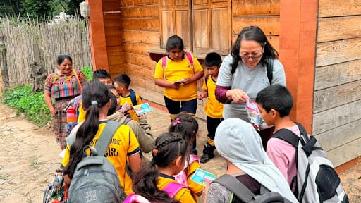 The children gather around Pastor Veronica as she shares gospel tracts and materials.