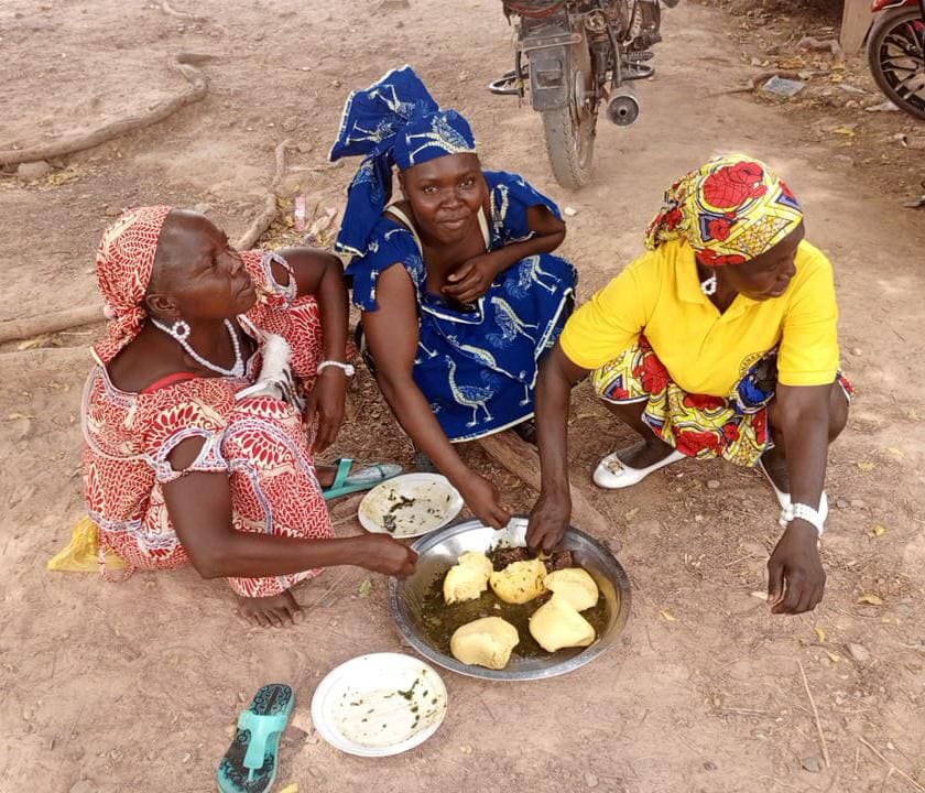 Three women eating on ground